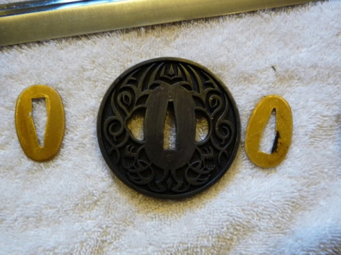 As you've noticed, the tsuba has a late-1990's tribal-tattoo look to it. As you've noticed, the tsuba has a late-1990's tribal-tattoo look to it.